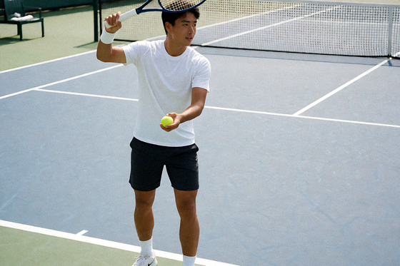 网球硬地赛场上的球员正在准备发球，球场边线清晰