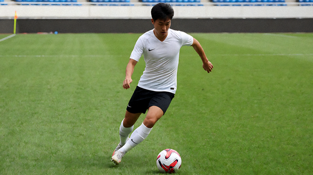 足球赛事现场，球员在绿茵场上进行比赛与争抢